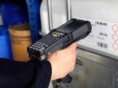 Human hand holding barcode scanner for scanning codes